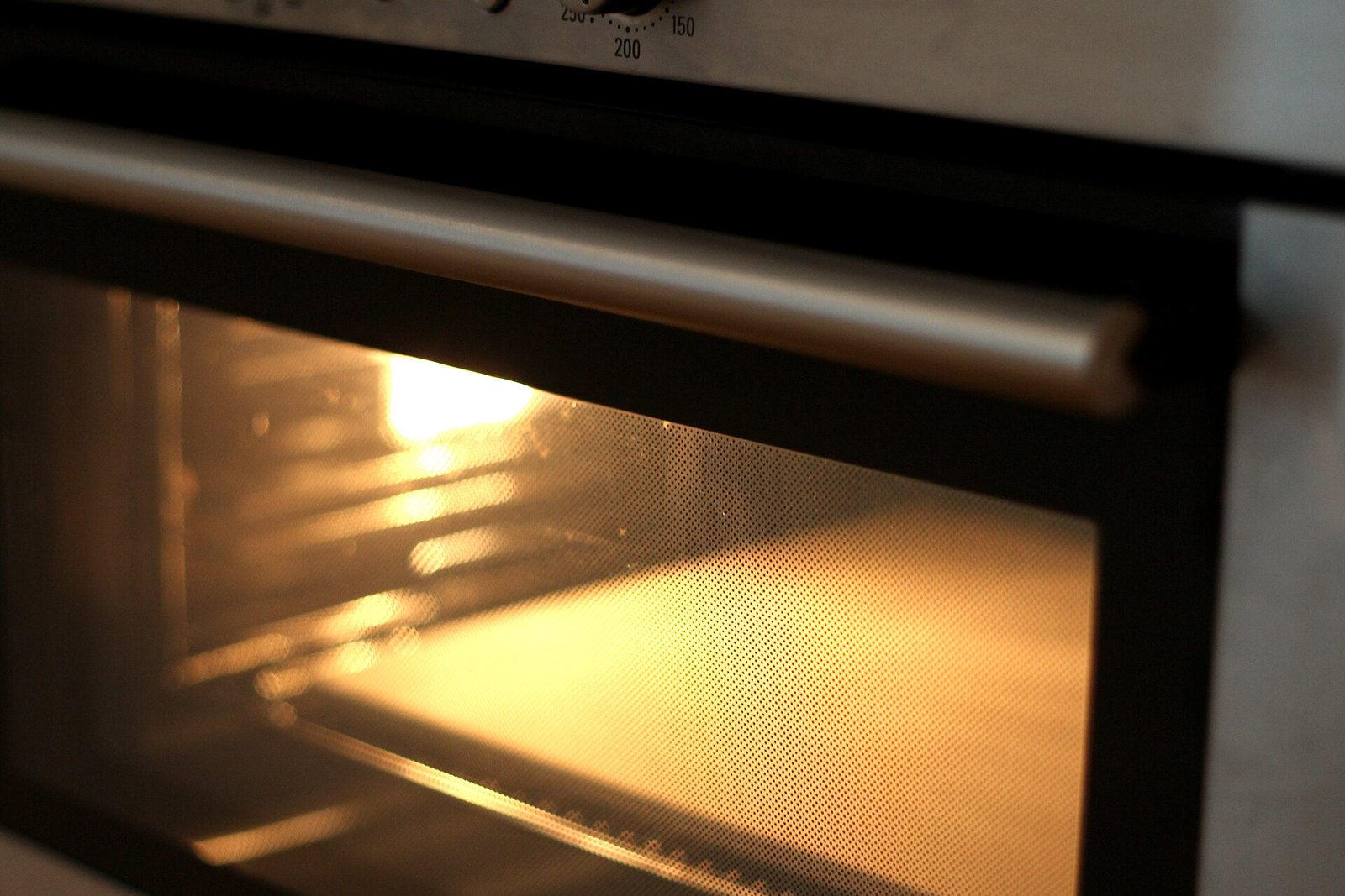 Baking stone heating on a rack inside a home oven