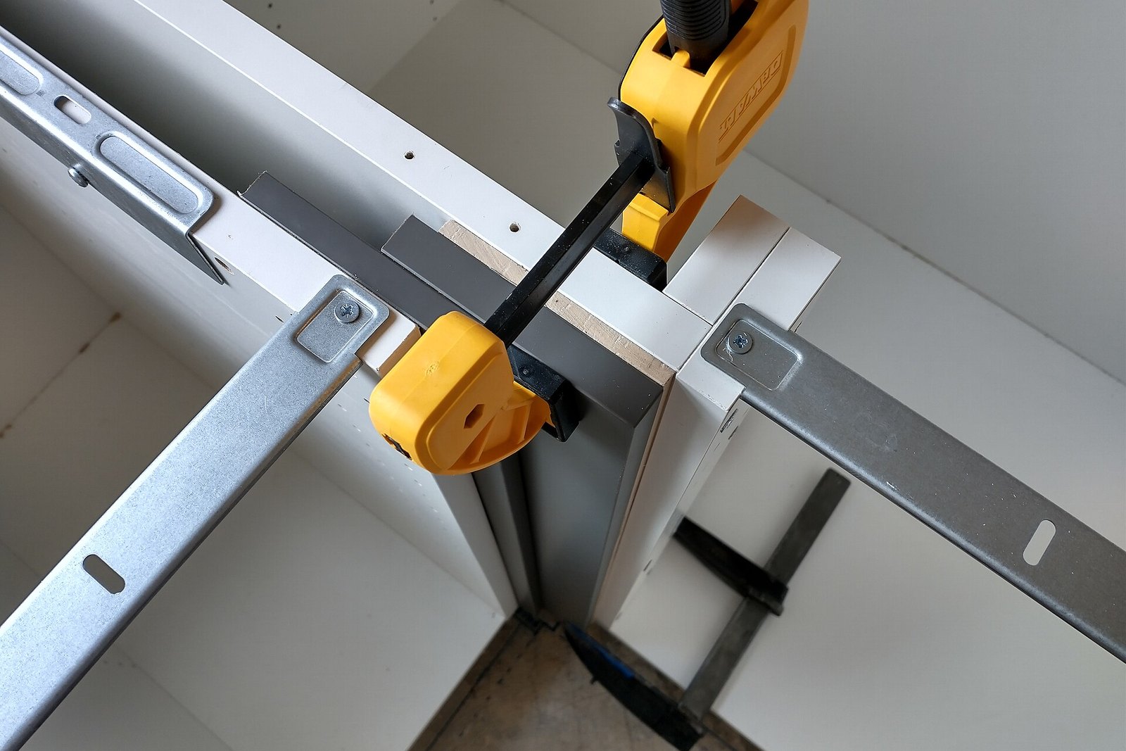 Kitchen cabinet framework held in alignment with clamps during installation