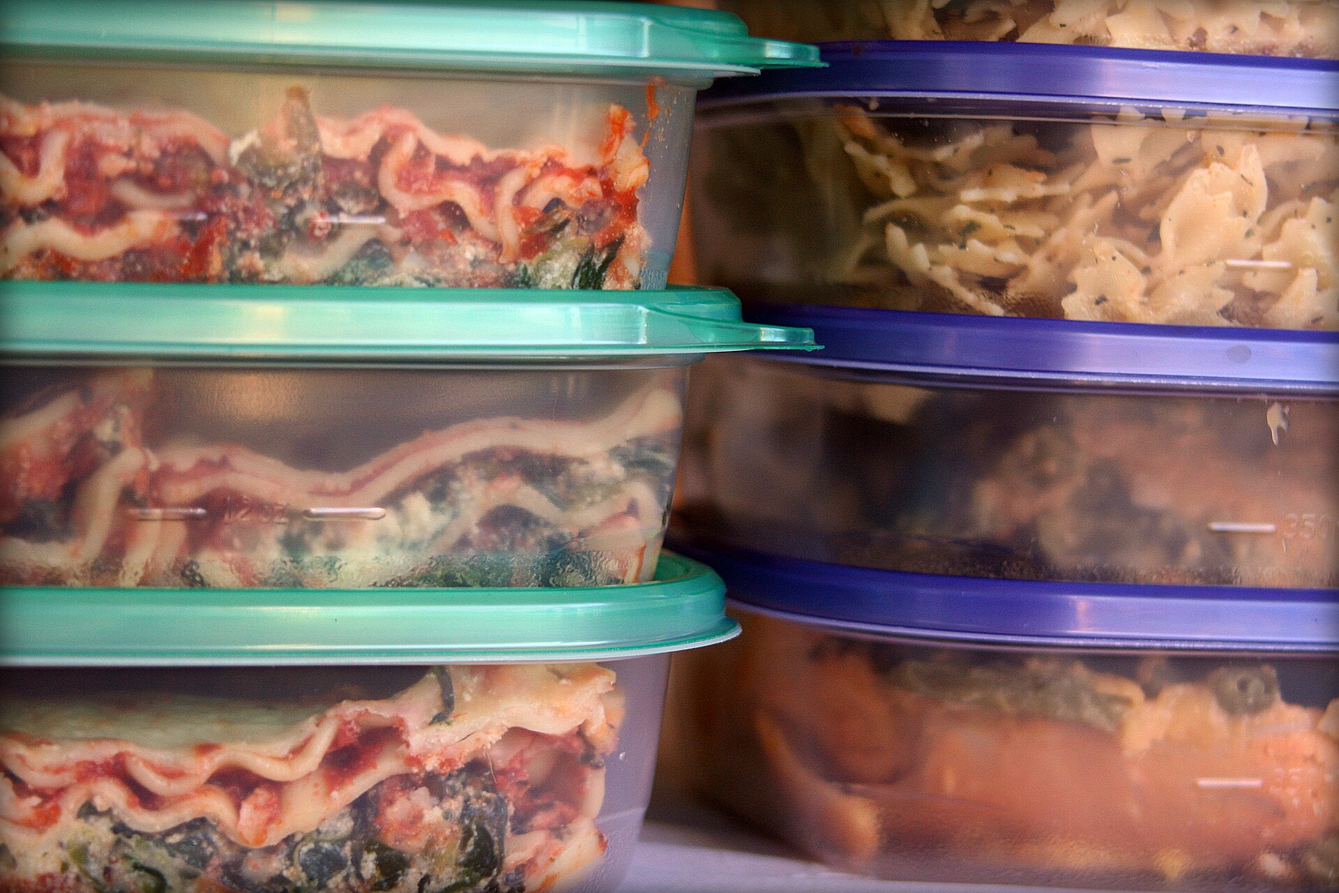 Leftover food stored in several lidded plastic containers ready for refrigeration
