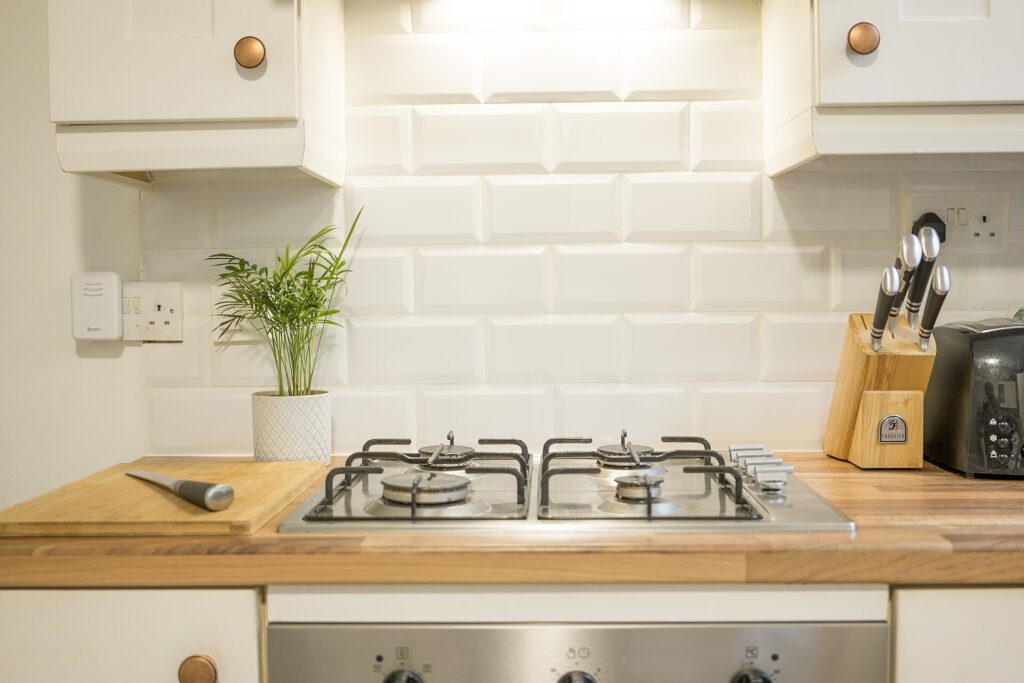 Wooden kitchen worktop with hob, knives and practical daily-use equipment
