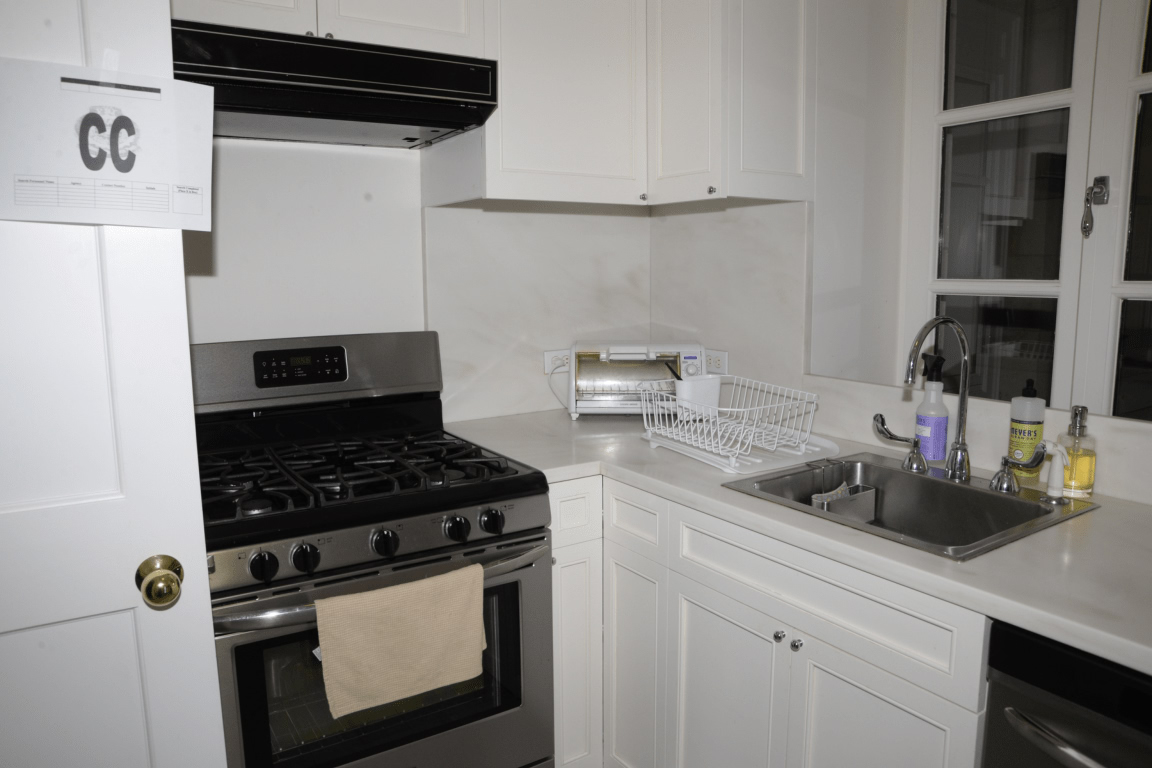 EFTA00000303 - Modern kitchen with white cabinets stainless steel appliances and a sink area equipped with dish soap and a drying rack for sink caddy and dish drying rack buying guide